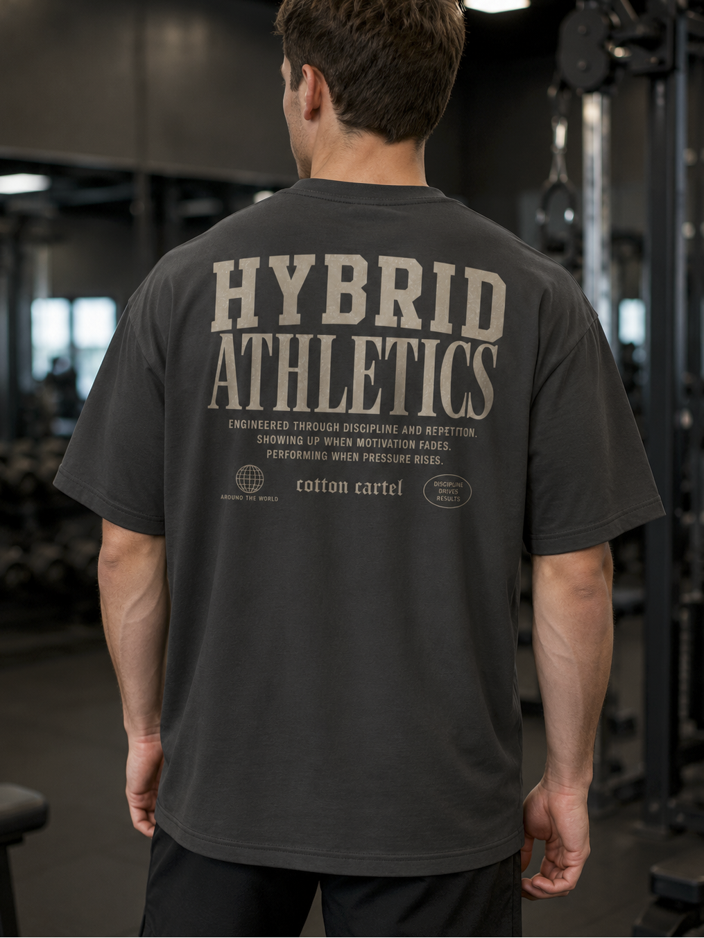 Person wearing a 'Hybrid Athletics' t-shirt in a gym setting