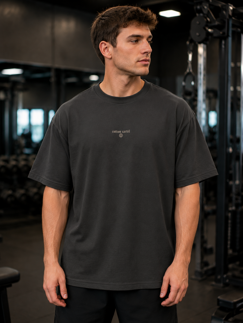 Man wearing a black t-shirt with text in a gym setting