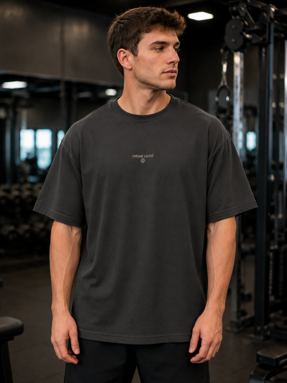 Man wearing a black t-shirt with text in a gym setting